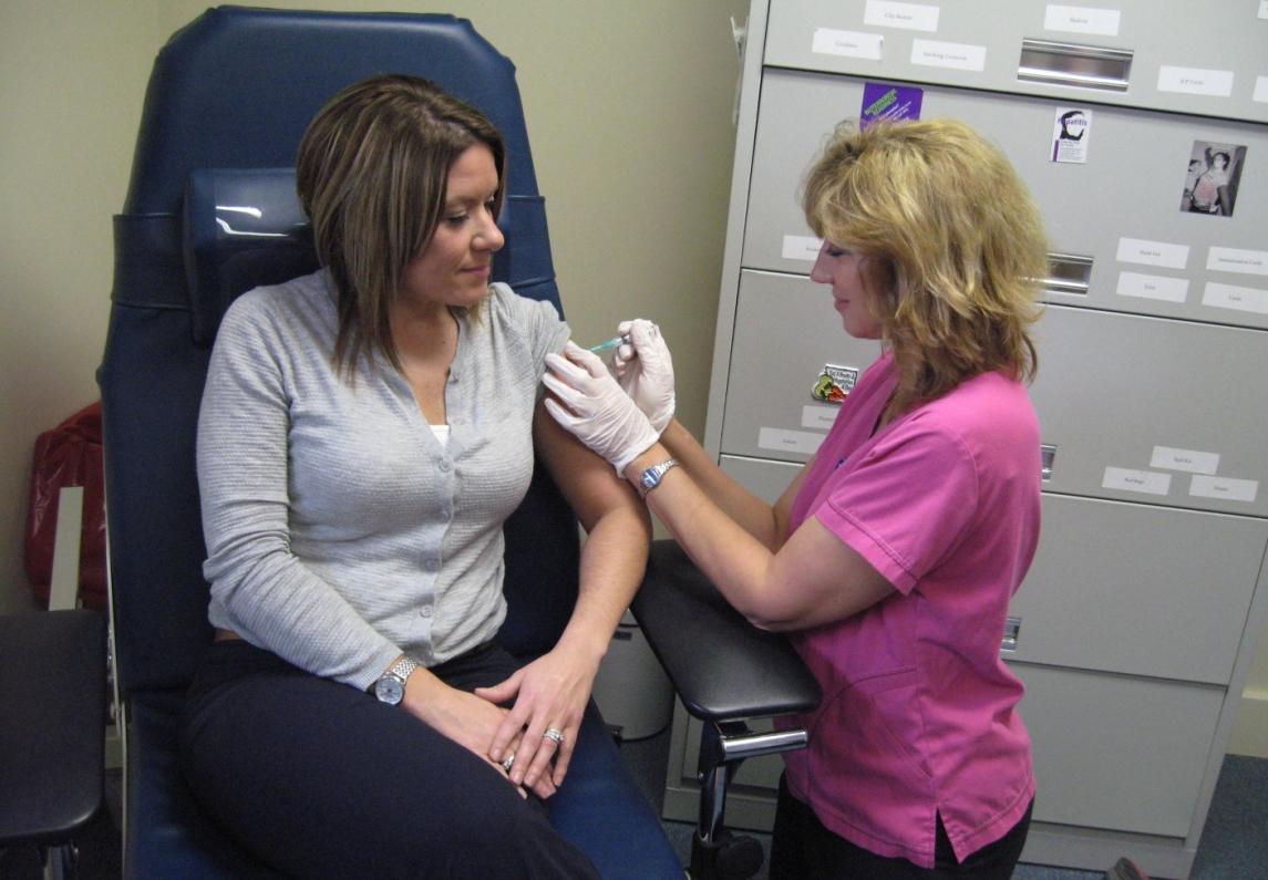 Community Health Nurse Suzanne Skelton gives Personnel Officer Nicole Yaggle a flu shot.