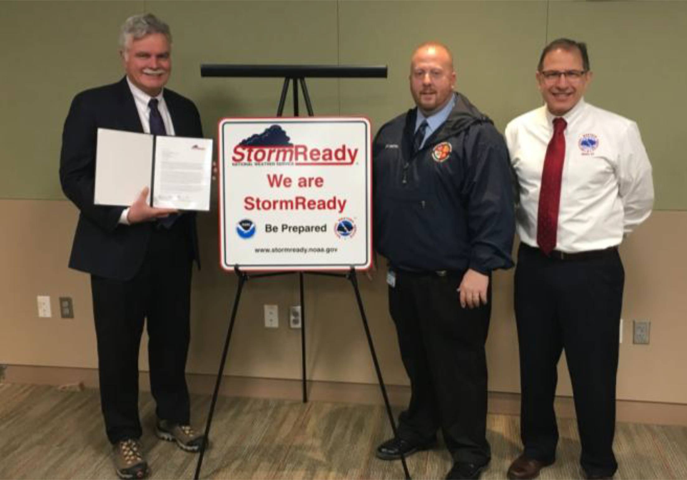 Representatives from the National Weather Service present Montgomery County with a StormReady sign and letter designating the achievement of becoming certified storm ready.