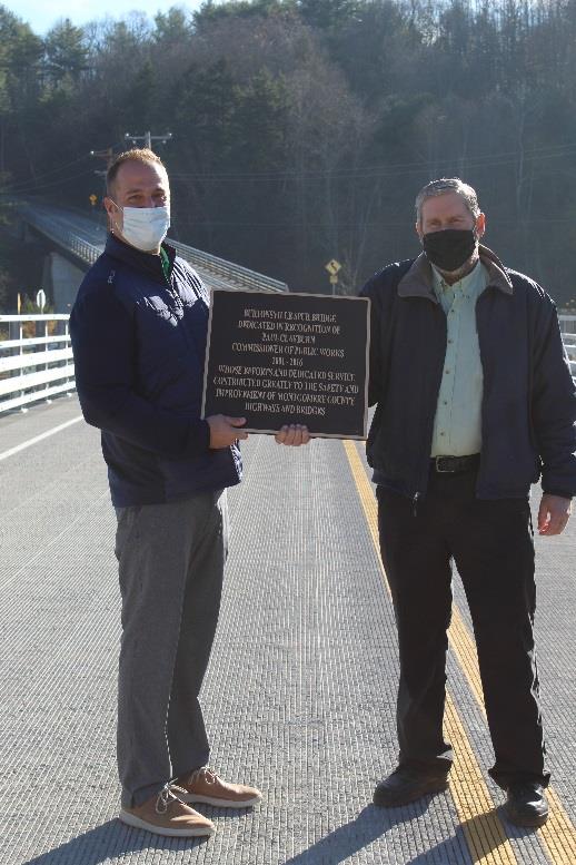 Montgomery County Executive Matthew L. Ossenfort stands with former Department of Public Works Commissioner Paul Clayburn after dedicating the Burtonsville Road Spur Bridge to him during a ribbon cutting ceremony for the structure Thursday. 