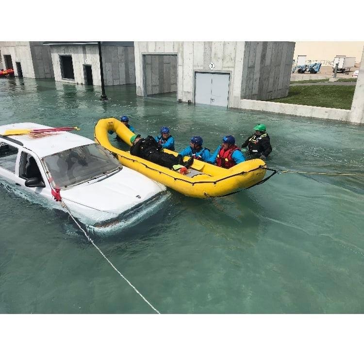 Swift Water Rescue Training - people practicing rescuing a person in a raft